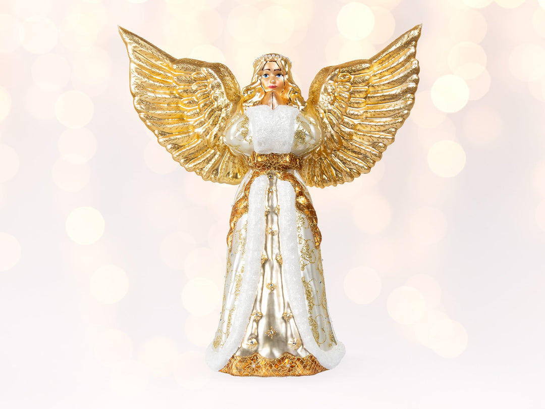 An angel ornament with gold wings wearing a gold white robe and white muff handwarmer.
