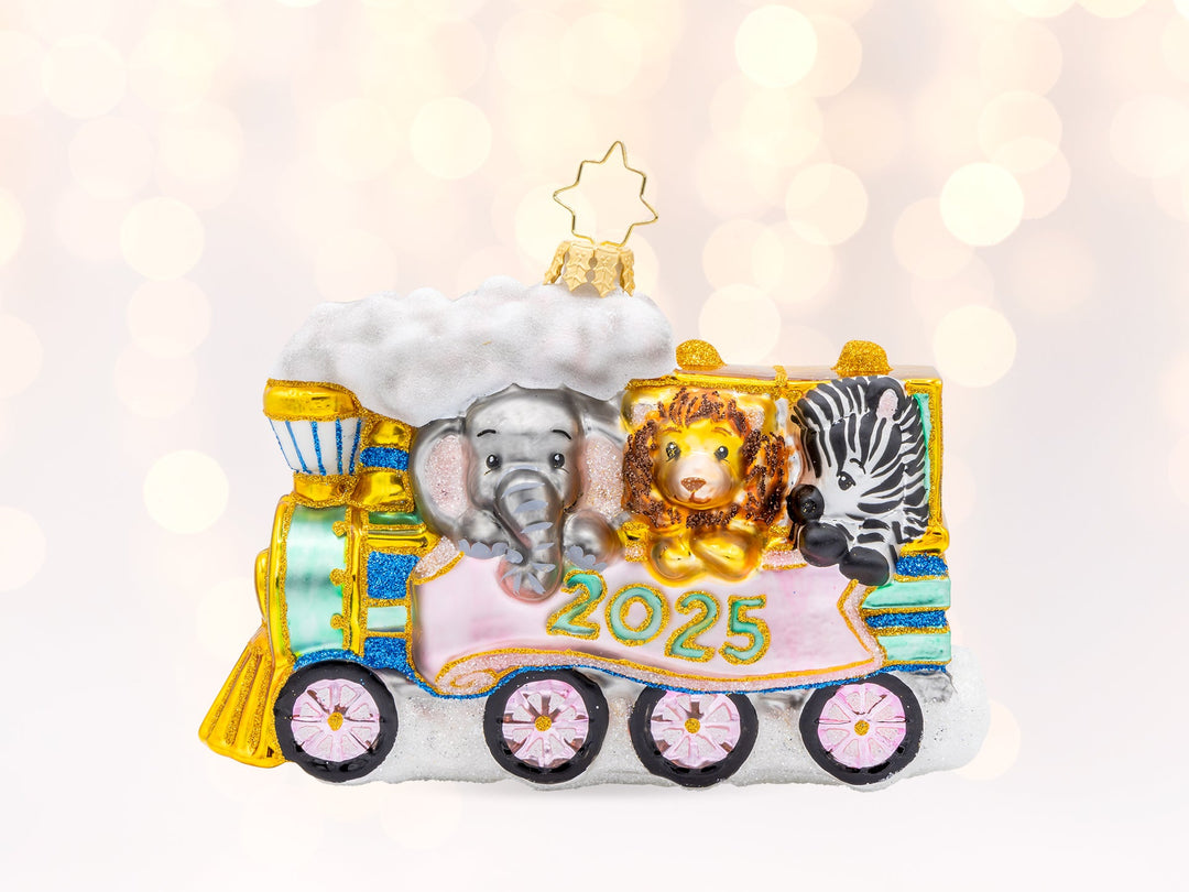 A baby blue train ornament dated 2025 with an elephant, lion, and zebra riding inside the train.