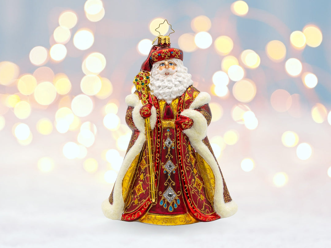 A red robed santa ornament with a red cape and gold cane.
