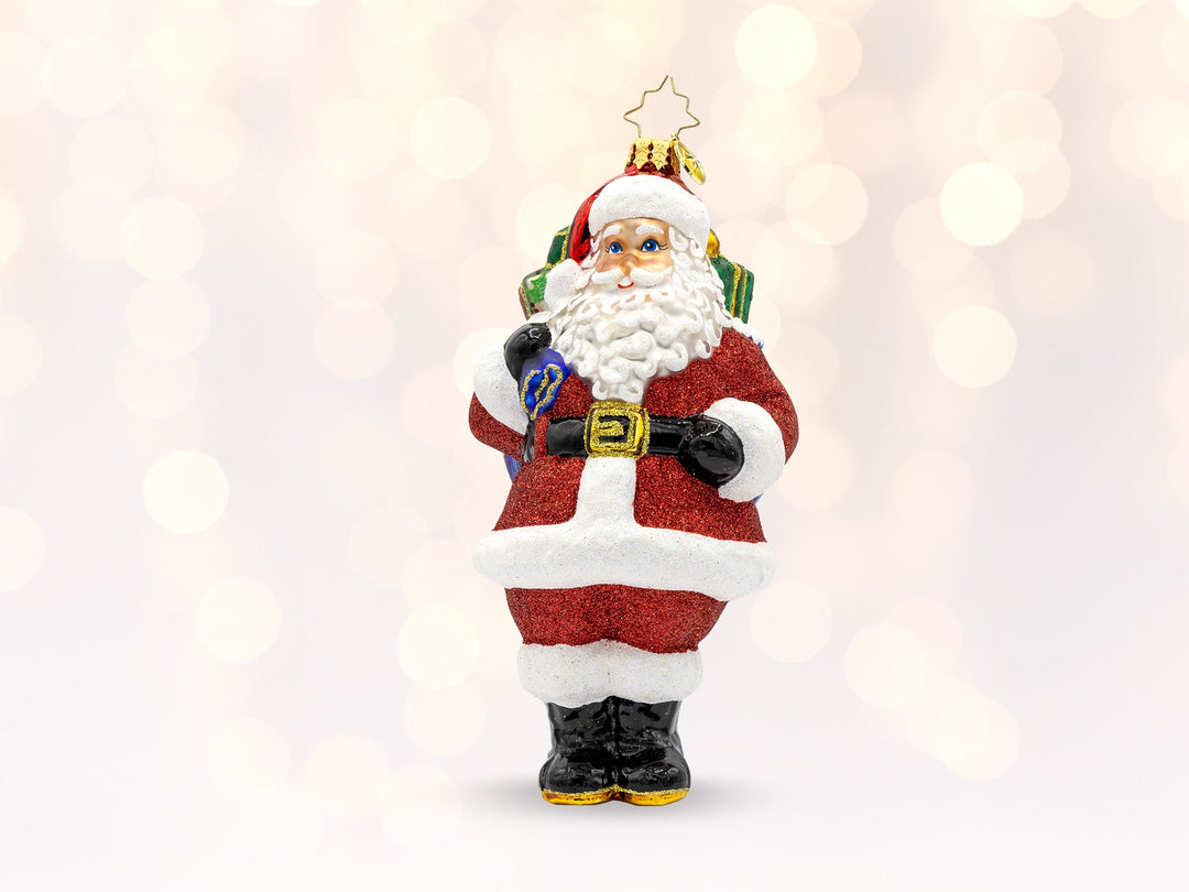 A red classic santa ornament holding a bag of gifts.