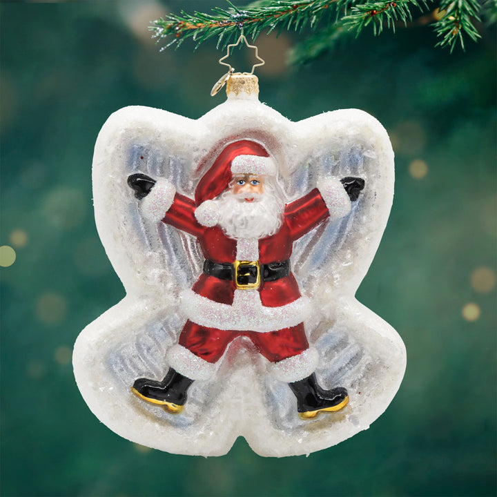 Snow Angel Duo ornament. Santa and Mrs. Claus are joyfully making snow angels in a blanket of sparkling snow. Santa is seen on front. View of front.