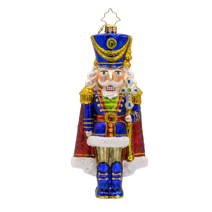 Long Coat Nutcracker ornament. Features elegant attire of regal blue and red accompanied by a dignified stance. View of front.