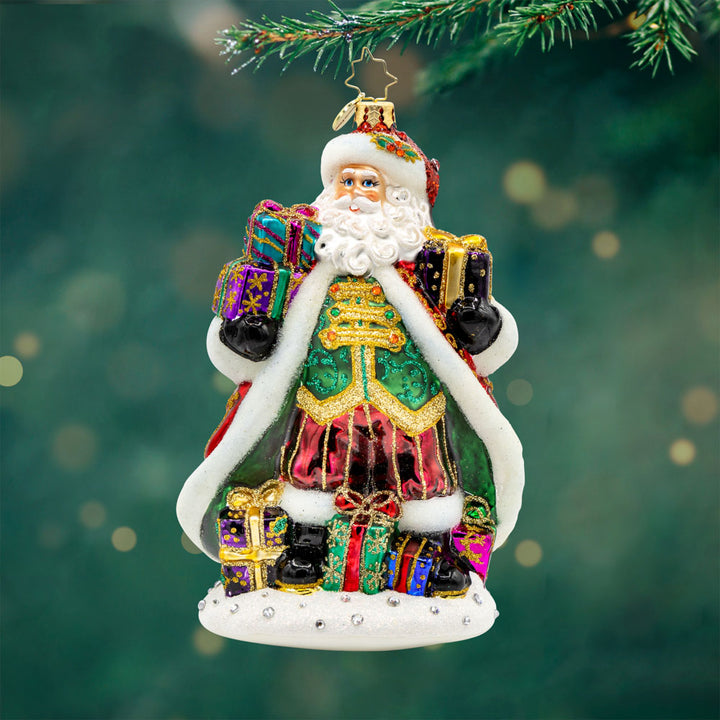 A Santa For All Seasons ornament. Santa in his intricately detailed satin coat surrounded by gifts galore. View of front.