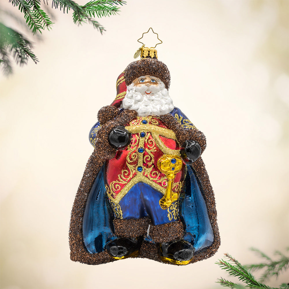 Keymaster Klaus ornament. Decked in a lush burgundy coat with champagne glitter accents and an intricate key motif. View of front.