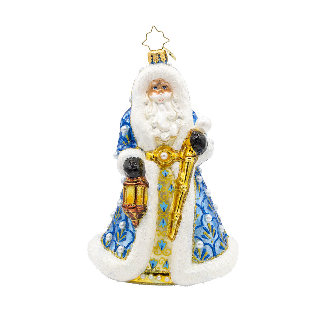 Gilded Grandeur Santa ornament. Dressed in a blue satin coat adorned with intricate designs, paired with his shiny staff and a lantern that casts a warm glow. View of front.