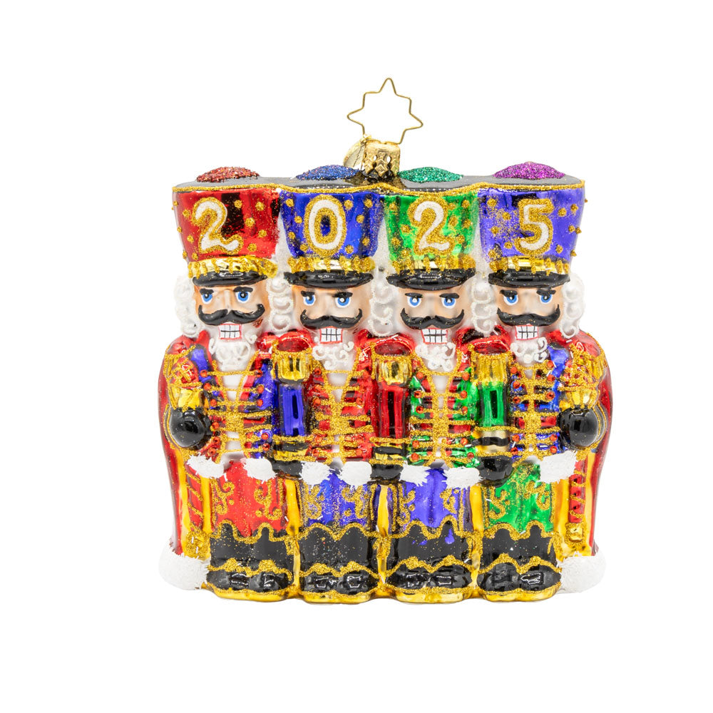 2025 Marching Guardians ornament. This ornament features a row of nutcrackers, with their shiny hats, sparkling sabers, and colorful costumes. "2025" is written across their hats. View of front.