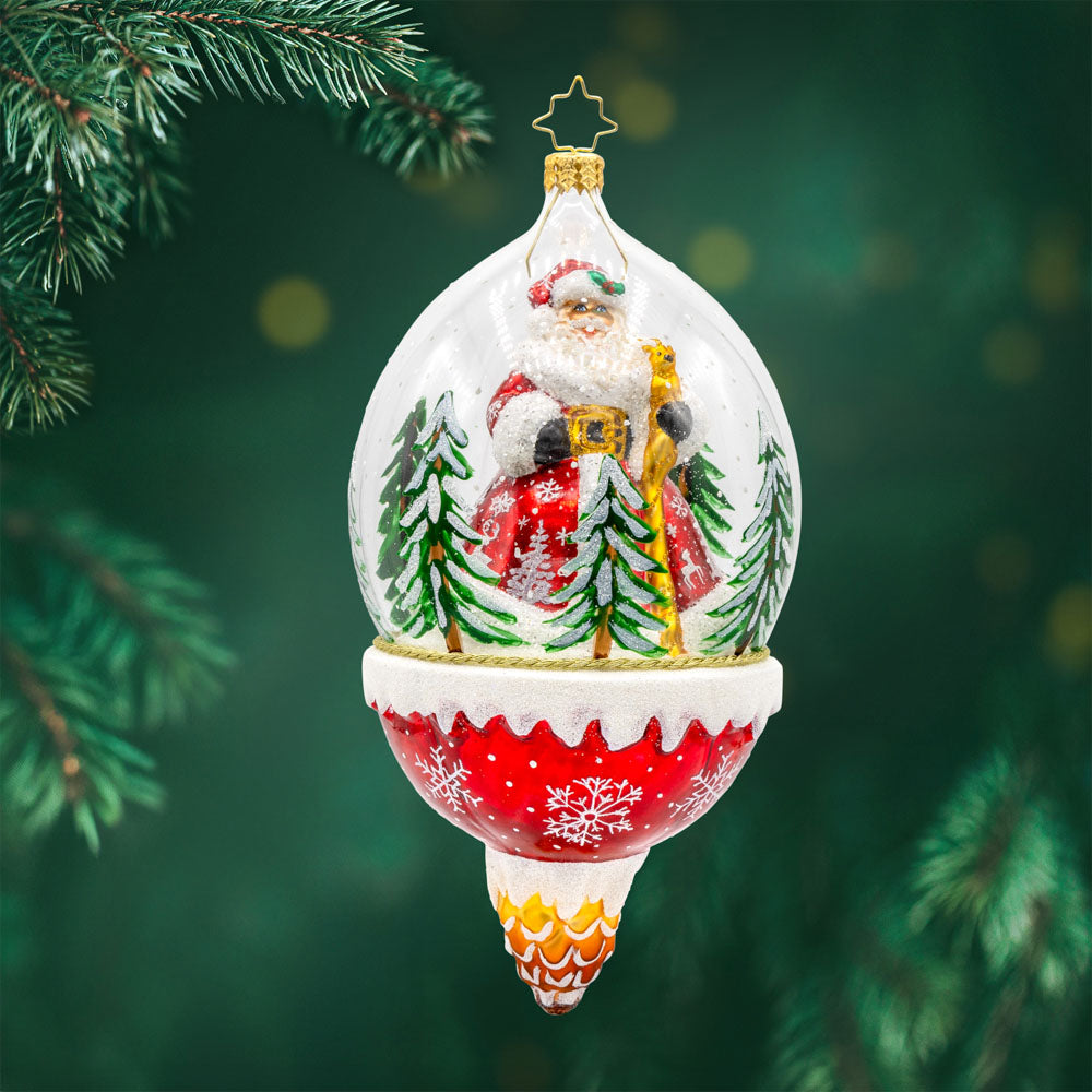 Winter Wanderlust ornament. This dome features a jolly Santa exploring a snowy forest with a playful deer. The shimmering snow, twinkling lights, and festive details create a magical atmosphere. View of front.