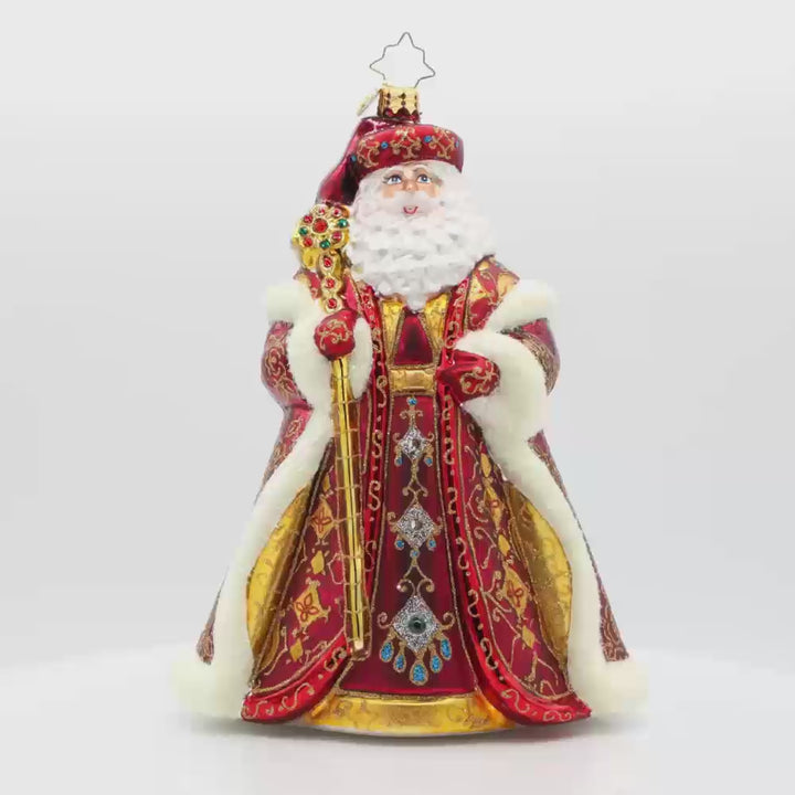 Years In the Making Nick ornament. Santa dons a deep satin red coat and a shimmering gold staff. The intricate patterns on his coat and the attached gems add a touch of opulence and elegance. Video.