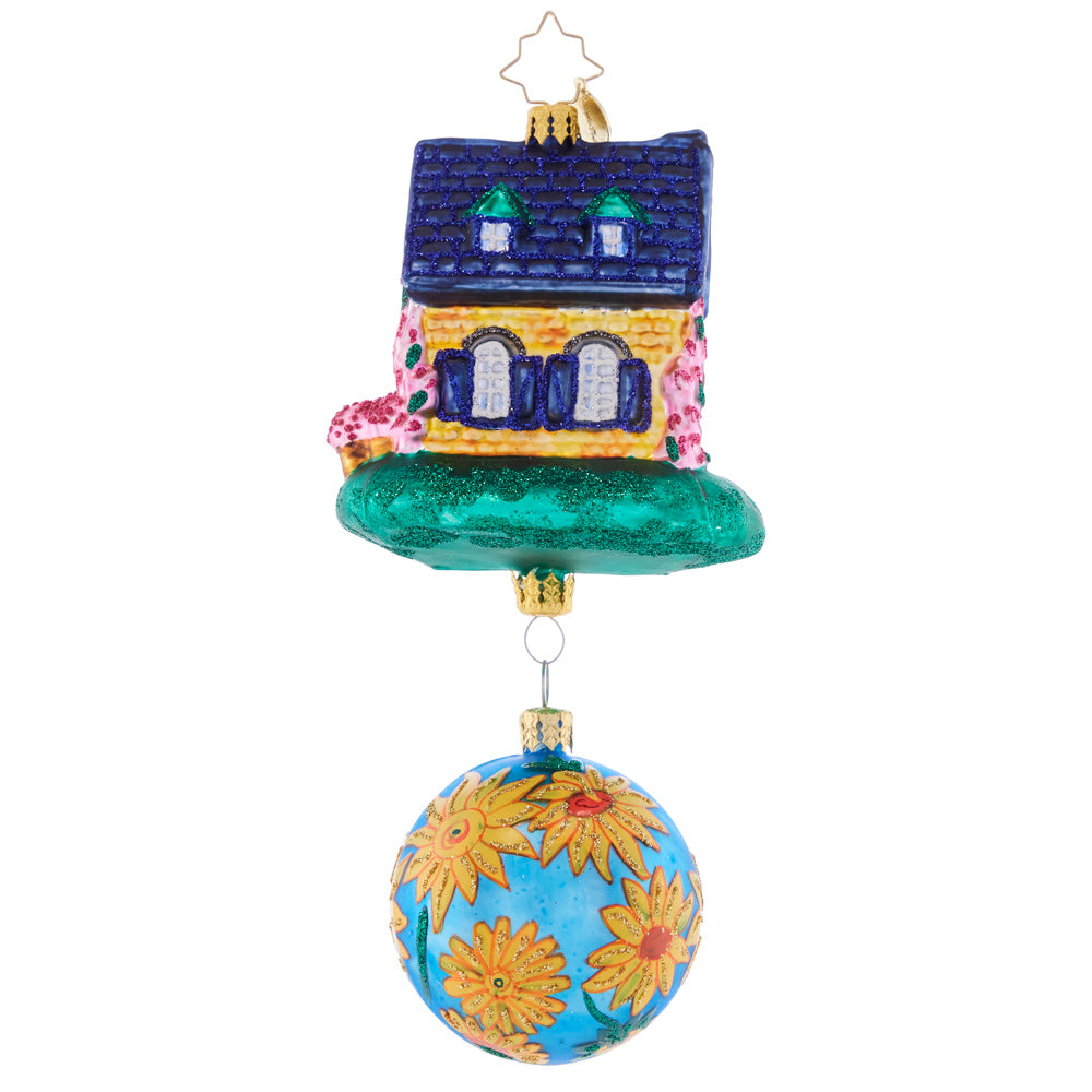 Back - Ornament Description - Countryside Cottage: A vibrant flower-adorned blue round accompanies this colorful and happy-looking house. Welcome home holiday memories with this joyful piece!