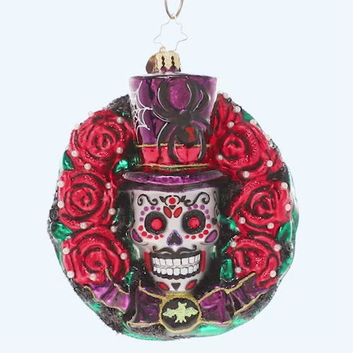 Video - Ornament Description - Spooky Skull Wreath: Celebrate spooky season with this gothic-inspired calavera wreath. A ring of blood-red roses encircles a trio of black bats and a grimacing sugar skull – all things that make Halloween so frightfully fun! This video shows the ornament spinning slowly.