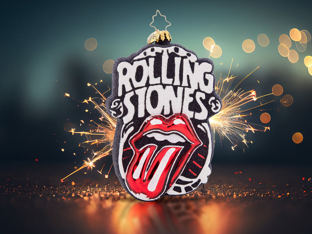 A black and white ornament that spells out Rolling Stones and has a pop of red color of the lips sticking out the tongue.
