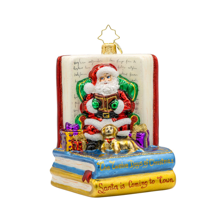Ornament features Santa Claus, the jolly old elf, engrossed in a classic holiday tale. Dressed in his traditional red suit and hat, Santa sits comfortably in a plush armchair, surrounded by stacks of books, including the beloved "Twas the Night Before Christmas. View of front.