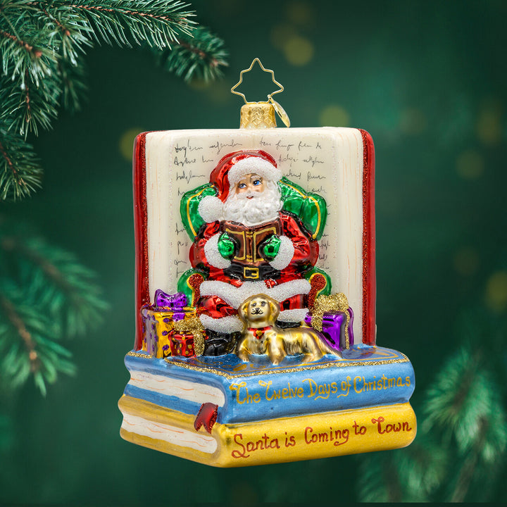 Ornament features Santa Claus, the jolly old elf, engrossed in a classic holiday tale. Dressed in his traditional red suit and hat, Santa sits comfortably in a plush armchair, surrounded by stacks of books, including the beloved "Twas the Night Before Christmas. View of front.