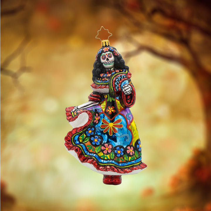 With her colorful dress, shimmering skull, and graceful pose, this vibrant Day of the Dead dancer is ready to take center stage! View of front of ornament.