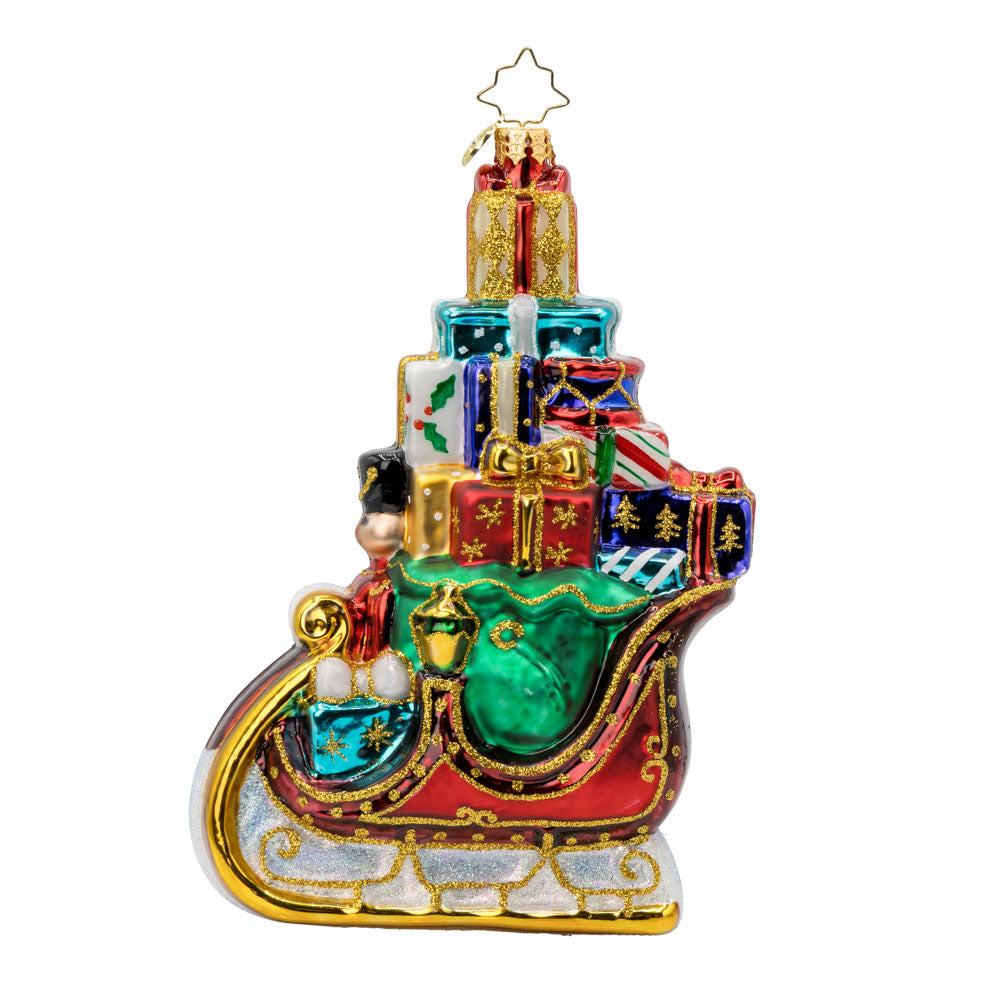 This enchanting ornament featuring Santa's sleigh overflowing with gifts. View of right side.