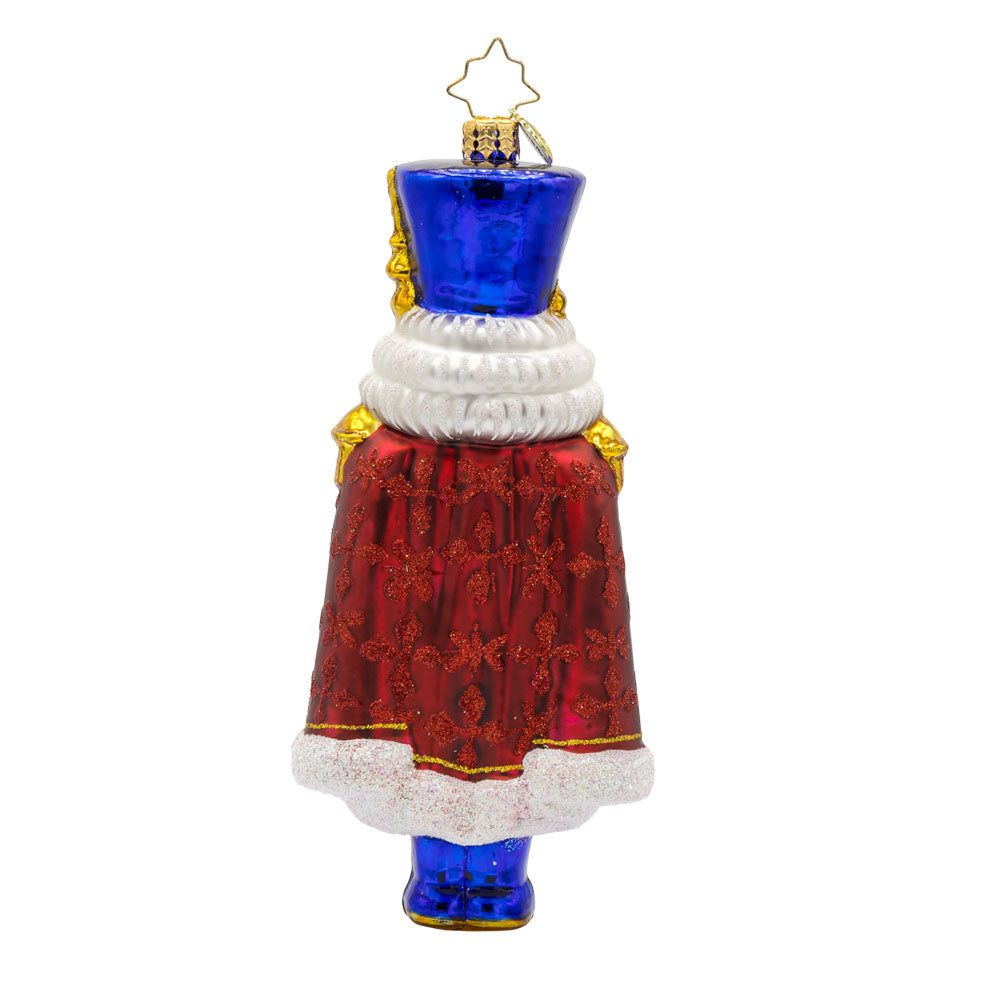 Long Coat Nutcracker ornament. Features elegant attire of regal blue and red accompanied by a dignified stance. View of back.