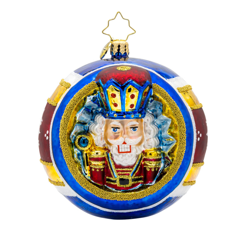 Nutcracker Spherical Splendor ornament. The ornament round features a nutcracker wearing red, blue, and gold, surrounded by painted stripes of the same colors. View of front.