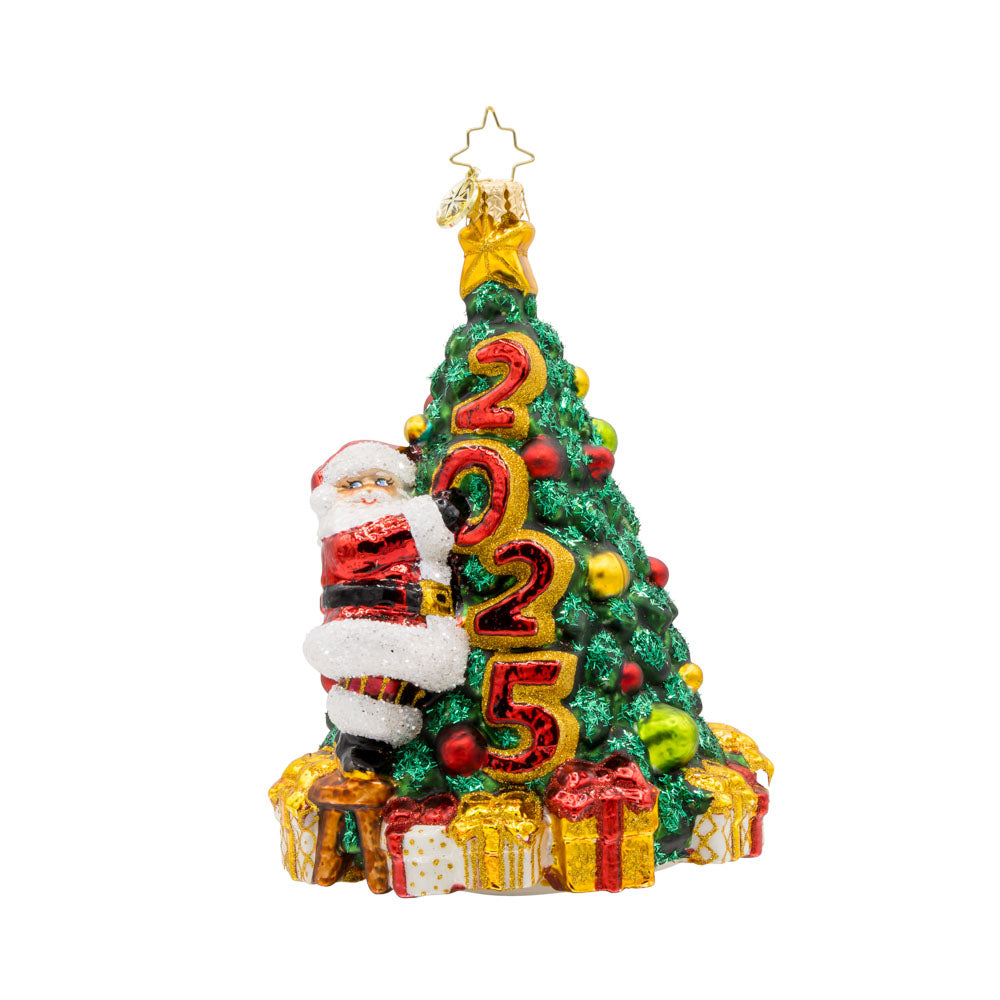 Santa's 2025 Tree Trim. Santa is seen decorating the Christmas tree with all the trimmings. Tree is dated with "2025." View of front. 