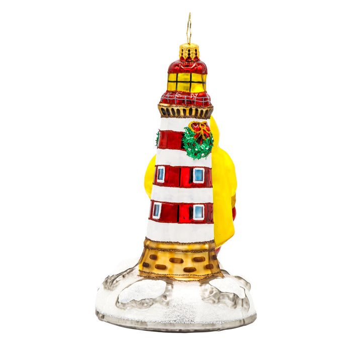 Santa's Coastal Haven ornament. Santa is wearing a yellow raincoat and boots standing next to a lighthouse. View of back.