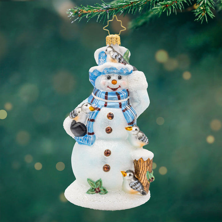 Snowy Perch Pals ornament. This snowman wears a blue and brown tartan scarf accompanied by feathered friends. View of front.