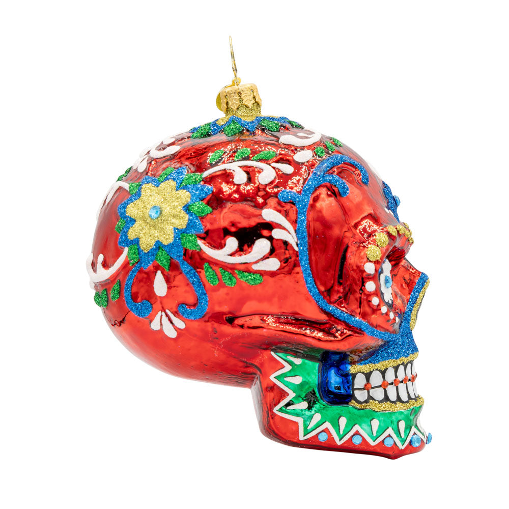Calavera Fiesta ornament. Day of the Dead decorated skull with vibrant colors and intricate details. View of left side.