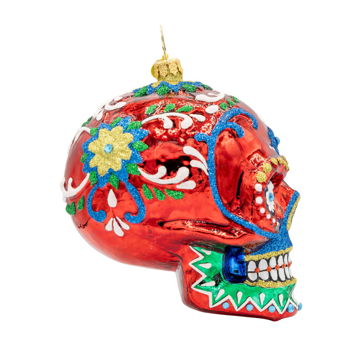 Calavera Fiesta ornament. Day of the Dead decorated skull with vibrant colors and intricate details. View of left side.