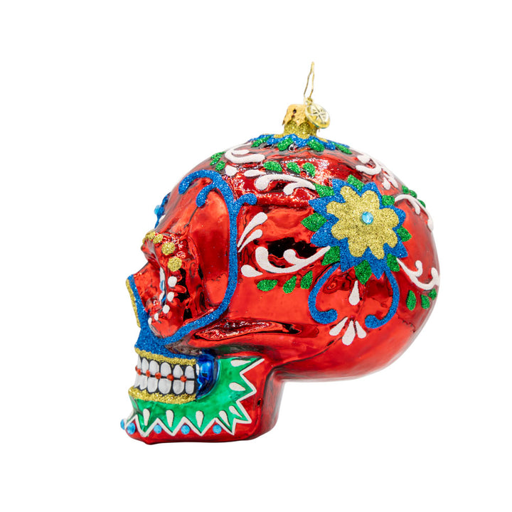 Calavera Fiesta ornament. Day of the Dead decorated skull with vibrant colors and intricate details. View of right side.