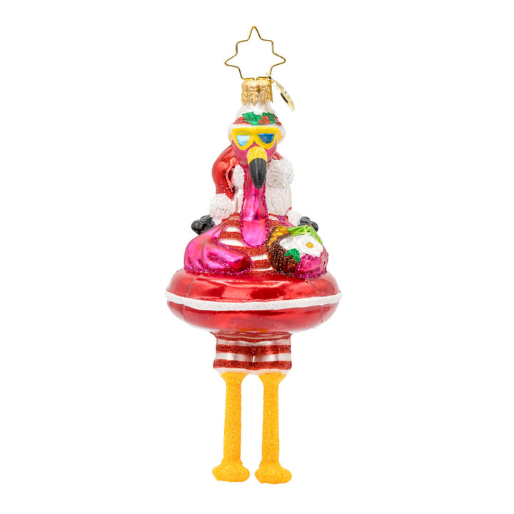 Floatin' Flamingo Fun ornament. Features a flamingo relaxing on a Santa tube, sipping from a coconut. View of front. 
