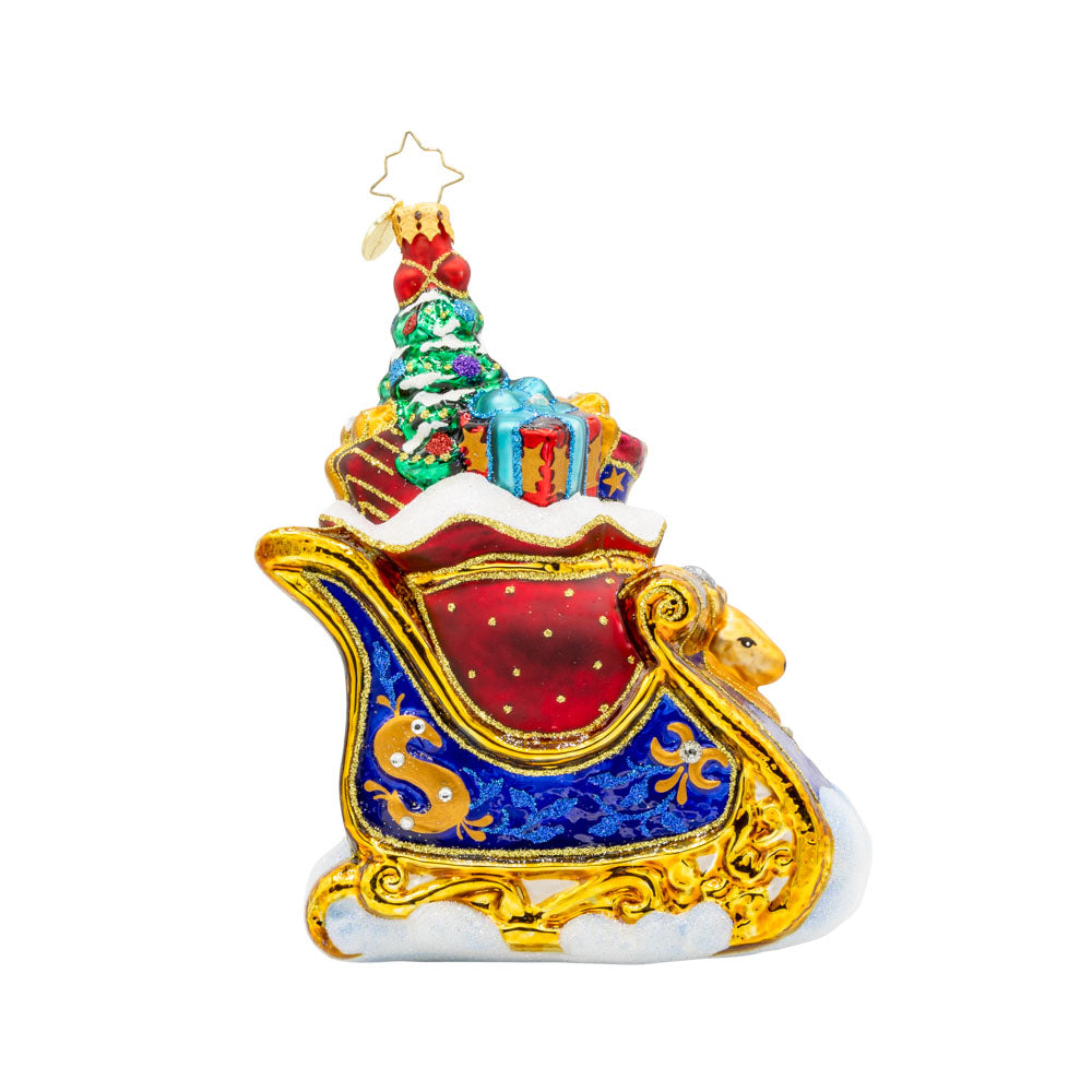 Celebratory Sleighride ornament. Royal Blue and gold sleigh, adorned with shimmering jewels and regal ribbons. View of front. 