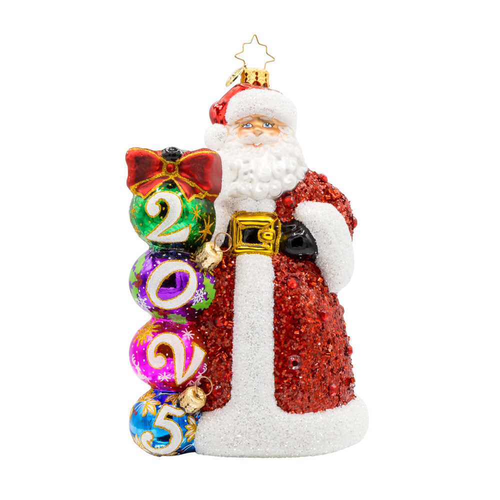 2025 Christmas Countdown ornament. Santa dons a glittering red jeweled coat.  Ornaments with "2025" written on them are stacked next to his side. View of front.