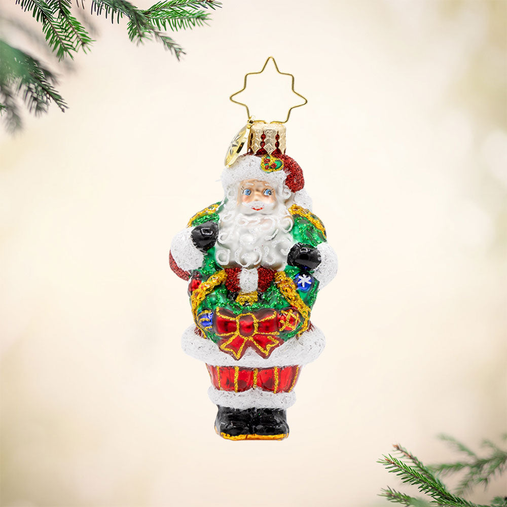 Wreath Wrangler Claus Gem ornament. Santa is seen here with a decorated Christmas wreath around his neck. View of front. 