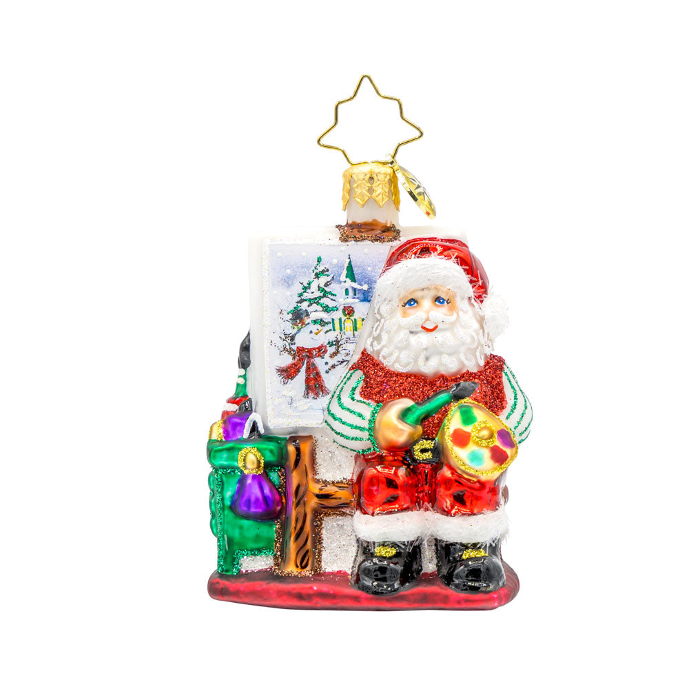 Pretty As A Picture Gem ornament. Santa is seen here painting a Christmas scene on a canvas. View of front.