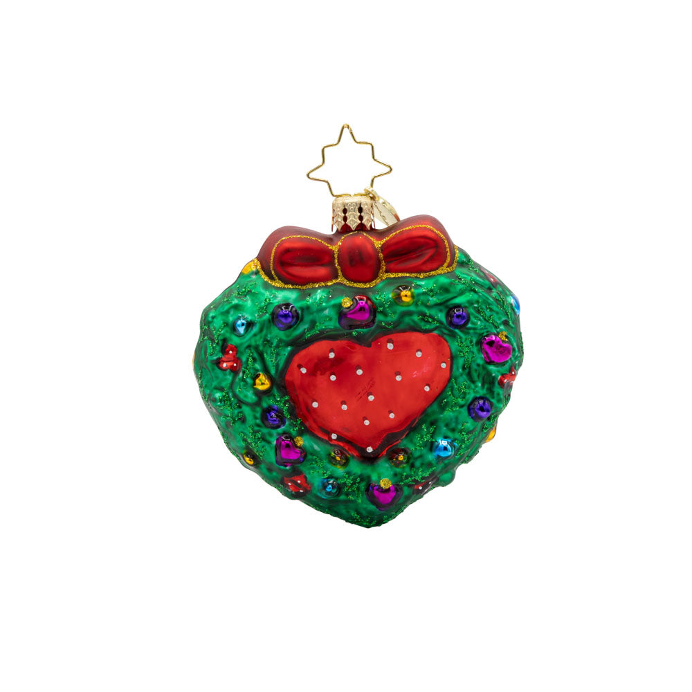 Mr. & Mrs. Claus Mistletoe Moment Gem ornament. Mrs. and Mr. Claus are seen hugging, encircled by a festive wreath shaped like a heart. View of back.