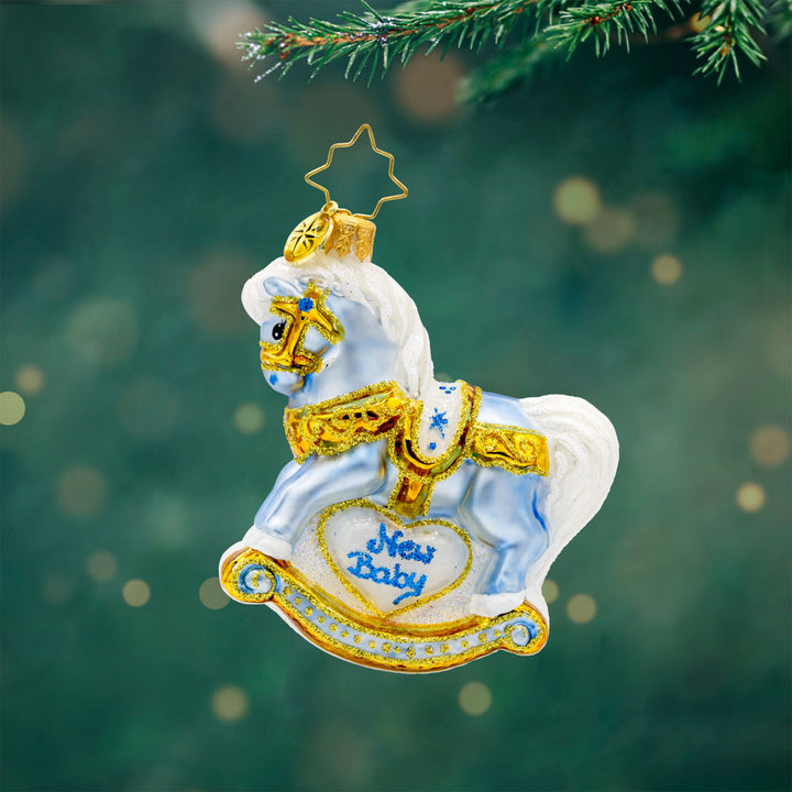 Baby's First Christmas Foal Gem ornament. A powder blue rocking horse with "New Baby" written on the side. View of front.