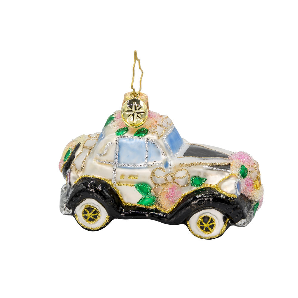 Wedding Day Wheels Gem ornament. A black and white car adorned with pink flowers and white bows. View of front. 