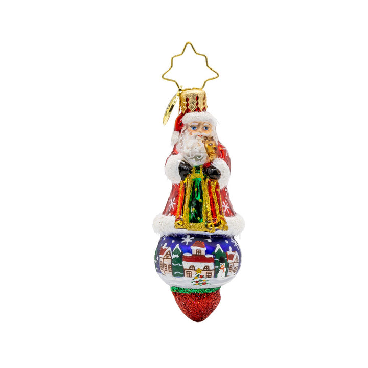 Santa's Splendid Snowscape Gem ornament. Santa stands atop a hand-painted scene of a snow-covered village. View of front. 