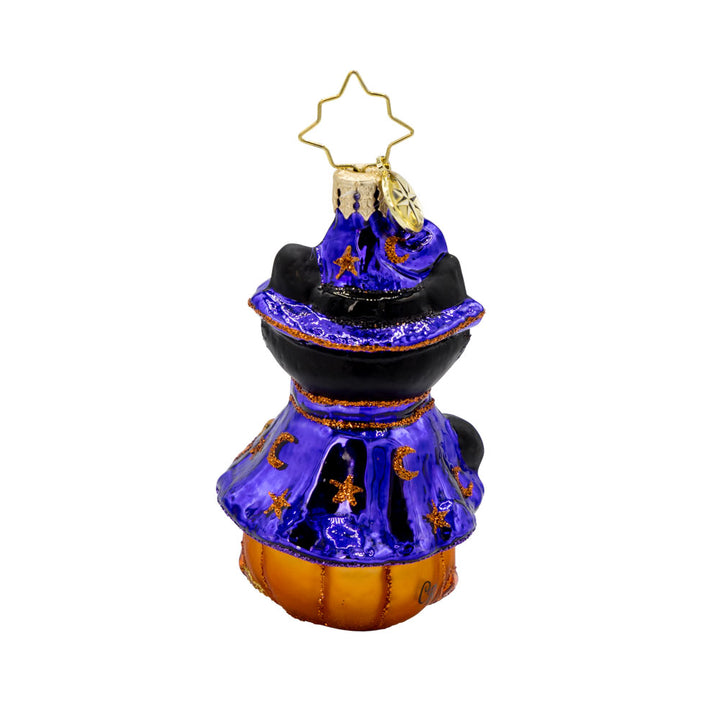 Witchy Whiskers Gem ornament. A black cat wears a purple witches' hat and cape, sitting atop a jack-o-lantern. View of back.