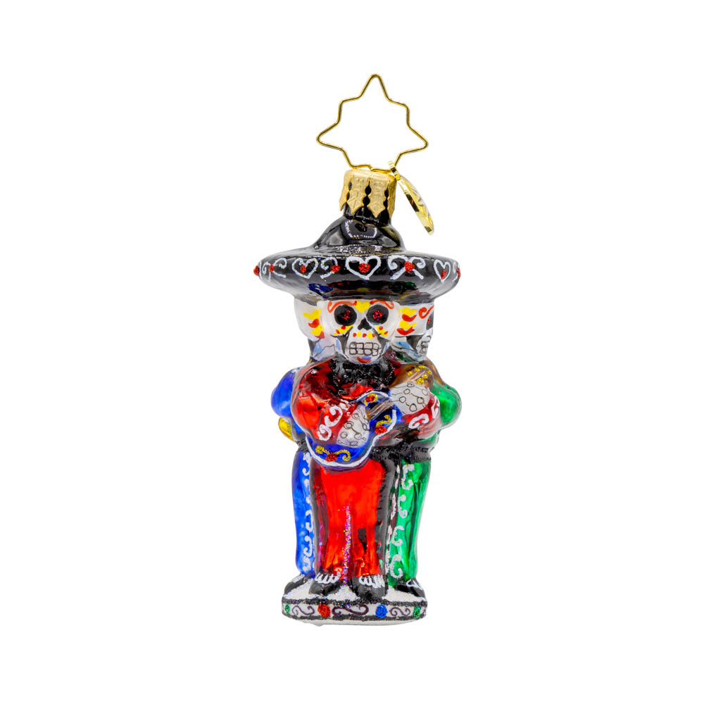 Skeleton Serenade Gem ornament. A band of three skeletons, instruments in hand, sombreros on head, dressed in festive green, red, and blues. View of front. 
