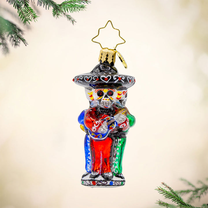 Skeleton Serenade Gem ornament. A band of three skeletons, instruments in hand, sombreros on head, dressed in festive green, red, and blues. View of front. 