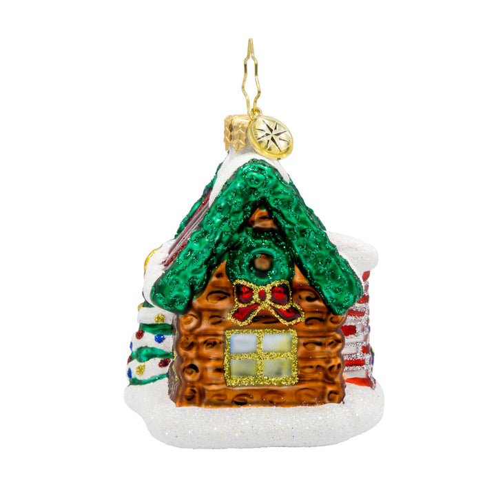 Hidden Woods Hideaway Gem ornament. A log cabin covered in snow and festive cheer. View of back.