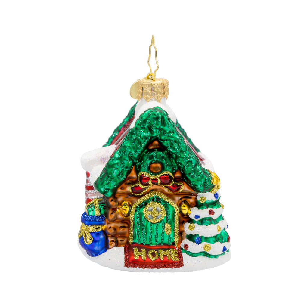 Hidden Woods Hideaway Gem ornament. A log cabin covered in snow and festive cheer. View of front. 