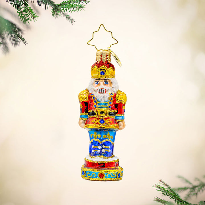 Royal Elegance Nutcracker Gem ornament. This nutcracker dons a red, blue, and gold suit. View of front. 