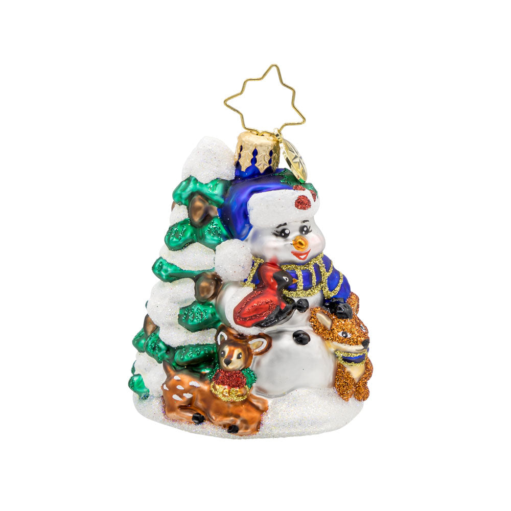 Wintery Pals Gem ornament. A snowman is seen with his forest friends in front of a pine tree covered in snow. View of front. 