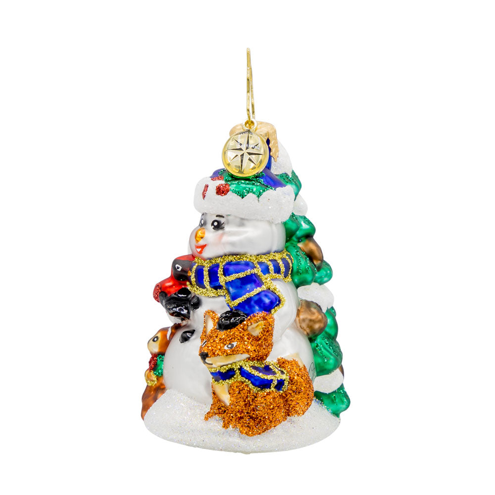 Wintery Pals Gem ornament. A snowman is seen with his forest friends in front of a pine tree covered in snow. View of right side.