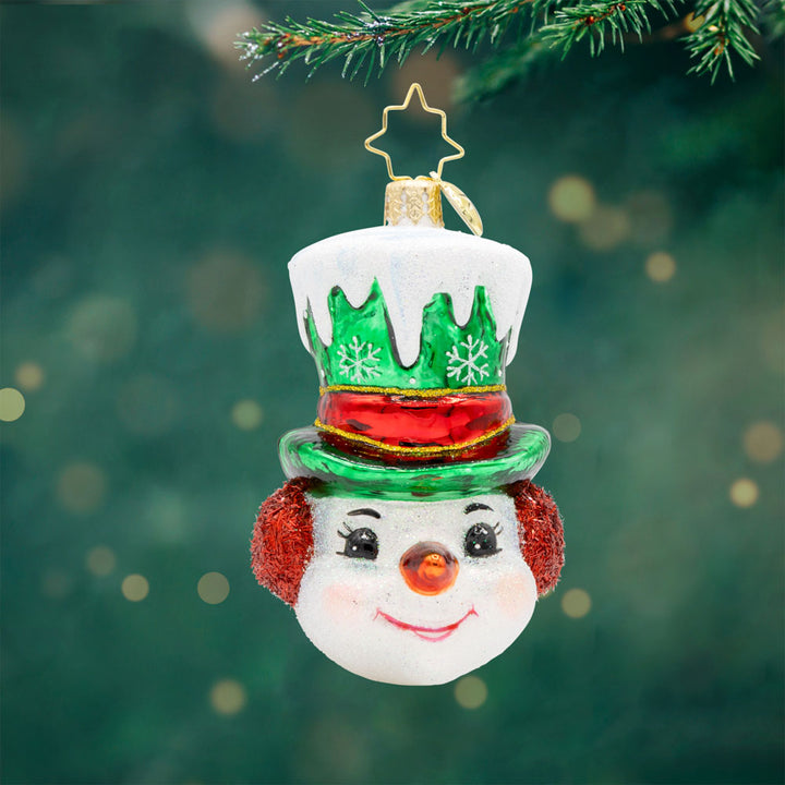 Top Hat Tidings Gem ornament. This snowman wears a green top hat, covered in snow with a red ribbon around it. View of front. 
