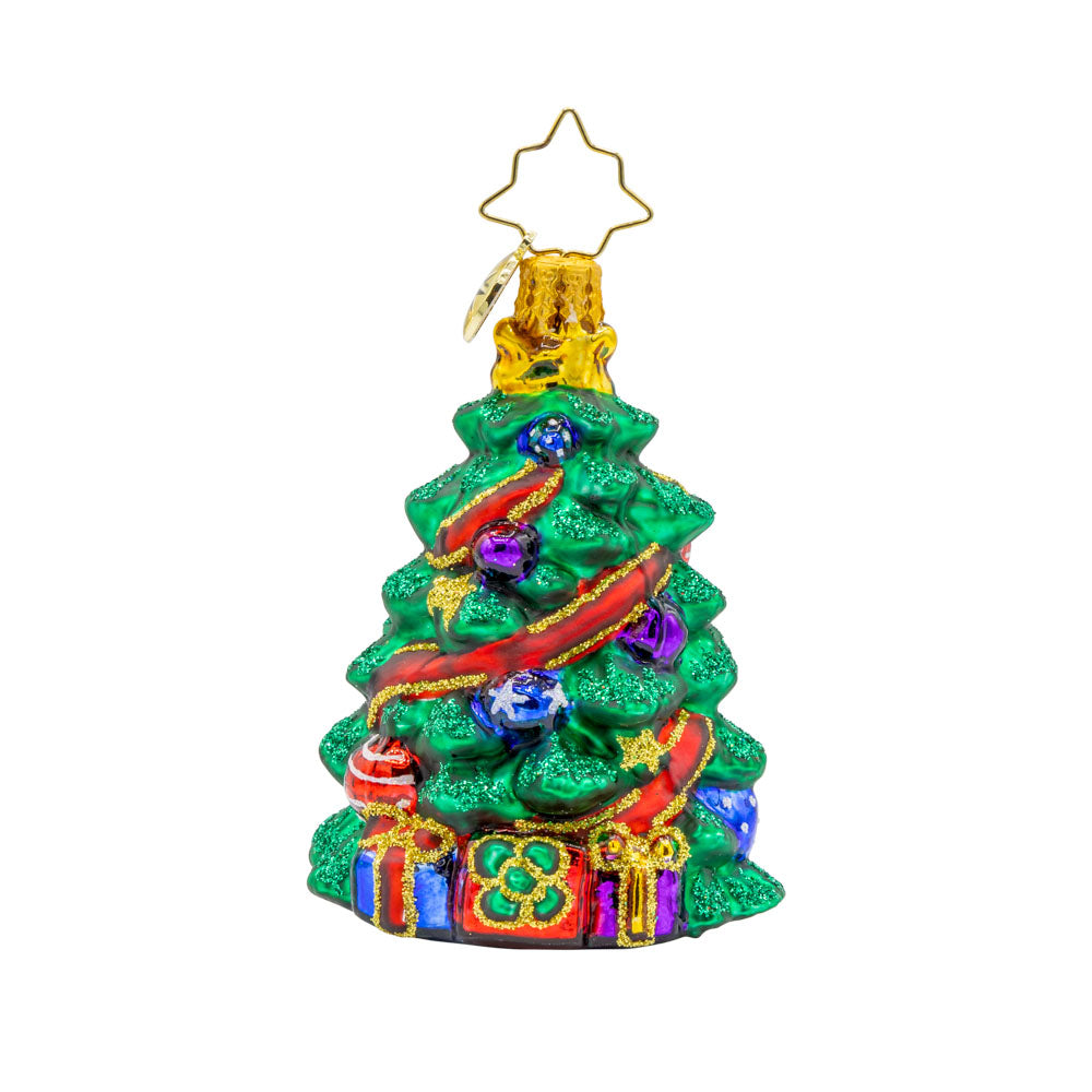 Wintery Tannenbaum Gem ornament. A decorated Christmas tree wrapped with a red ribbon. Gifts sit under the tree. View of front. 