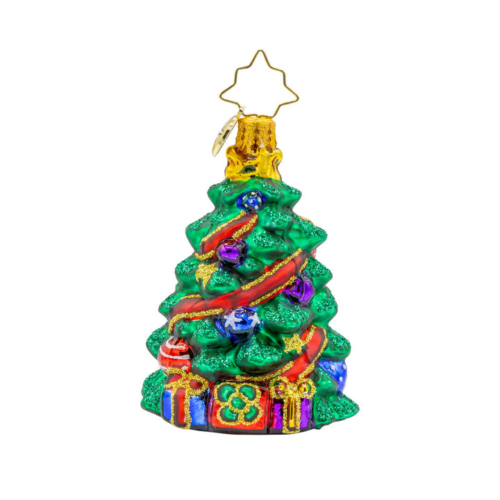 Wintery Tannenbaum Gem ornament. A decorated Christmas tree wrapped with a red ribbon. Gifts sit under the tree. View of front. 