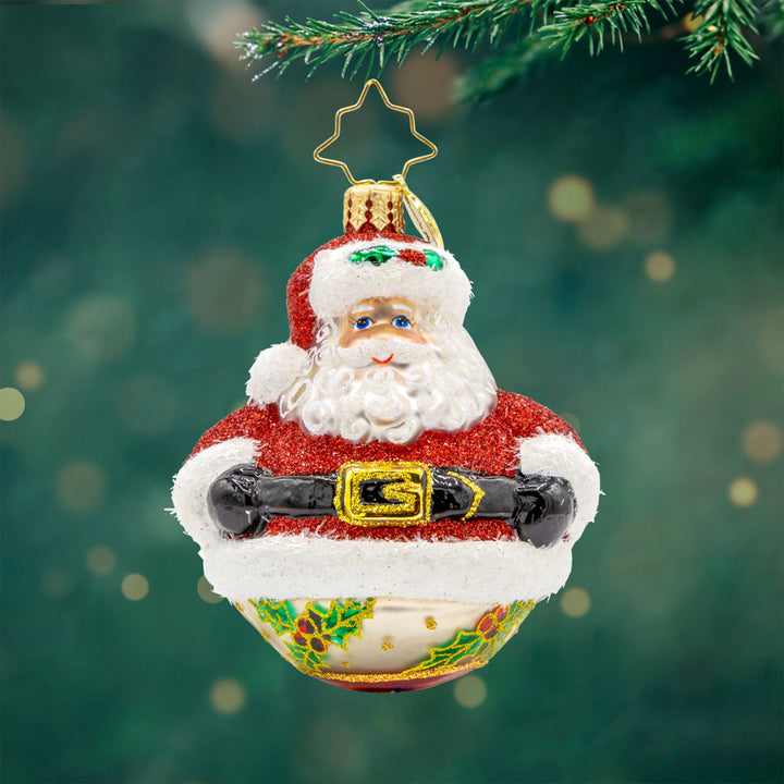 Jolly Holly Claus Gem ornament. Santa wears a sparkling red coat with white fur trim. His body makes up an ornament round featuring hand-painted holly on the underside. View of front. 