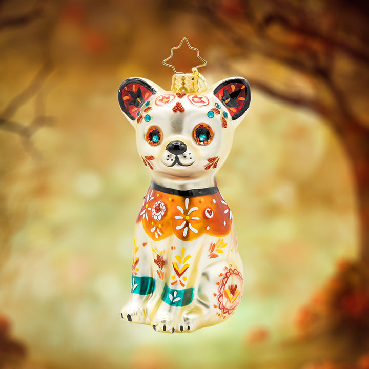 Fiesta Fido Calavera ornament. Inspired by Día de los Muertos, a dog painted with bold colors and intricate designs. View of front. 