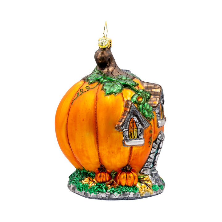 Pumpkin Patch Abode Ornament. Featuring a vibrant pumpkin exterior with windows, a whimsical door, and a leafy roof. View of left side.